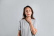 © New Africa - Mature woman doing thyroid self examination on light background