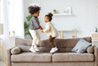 © JenkoAtaman - Happy energetic african american children jumping on sofa