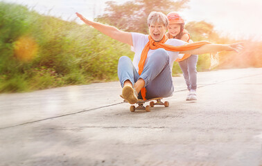 The child and senior to move on the skateboard outdoors