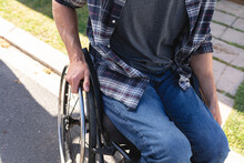 Mid Section Of Caucasian Disabled Man Sitting On Wheelchair On The Road