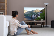 Woman Watching Television At Home. Living Room Interior With TV On Stand