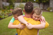 © wavebreak3 - Close up view of caucasian father hugging his two sons in the garden