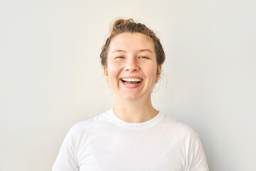 Young woman portrait. Pretty bussines face. Lifestyle happy emotions. White casual t-shirt. Looking at camera. Grey background. Copyspace. Adult people