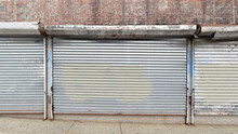 Plain Steel Roller Window Shutters With Paint On A Closed Brick Building In The Bronx