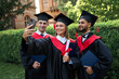 © Тарас Нагирняк - Three international graduate friends make selfie in graduating glows in campus
