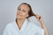 © evafesenuk - Mature woman in white bathrobe with wet hair after shower