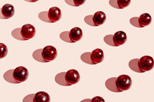Pattern Of Fresh Red Grapes Arranged In Lines On Pink Surface In Studio