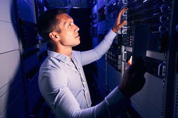 Wall Mural - System administrator inspecting storage hardware in server room