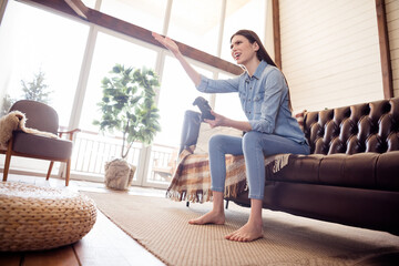 Sticker - Full size photo of unhappy upset young woman hold hand joystick play game sit sofa indoors inside house