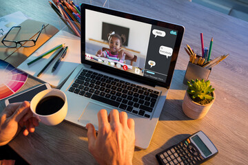 Wall Mural - Hands of man using laptop for video call, with african american elementary school pupil on screen