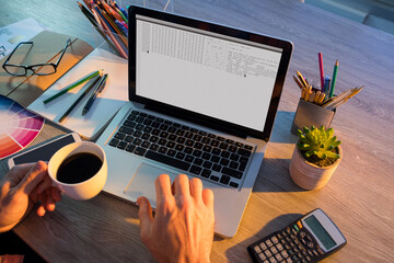 Hands of caucasian male programmer sitting at desk and using laptop with coding on screen
