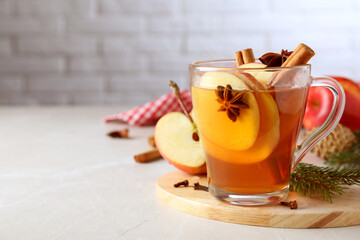 Aromatic hot mulled cider on light grey marble table. Space for text