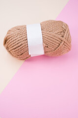 Canvas Print - Vertical shot of isolated soft beige yarn ball on an pastel pink background