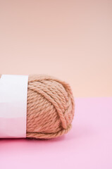 Canvas Print - Vertical shot of isolated soft beige yarn ball on an pastel pink background