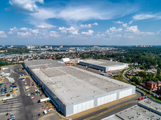 Huge warehouse building with flat roof and cars near city