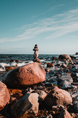 Wall Mural - Meditation zen stones stacked at a wild beach on a perfect sunny summer day with ocean background. Fehmarn at the German Baltic Sea in Germany
