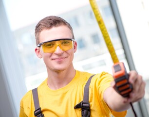 Young construction worker in yellow coveralls