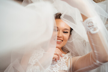 Wall Mural - beautiful bride in a lace robe lies in bed on a veil. morning before the wedding