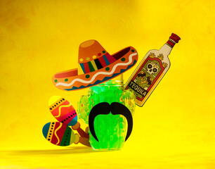 abstract background with mexican elements of sombrero, tequila, maracas, cactus and a glass mug in the form of a cactus on a yellow background, selective focus