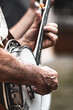 Mature adult Banjo bluegrass Band playing in outdoor concert with vertical close-up of hands