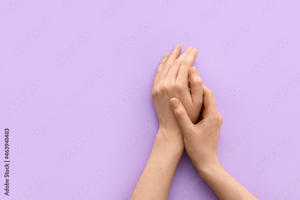 Female hands on color background