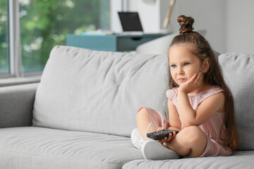 Adorable little girl watching TV at home