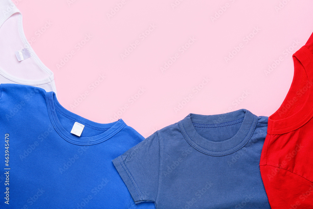 Stylish t-shirts on pink background, closeup