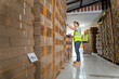 Warehouse worker courier inspecting checklist stock cardboard boxes for sale with warehouse workers characters unloading boxes.
