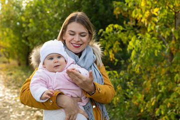 Wall Mural - Happy beautiful mother spending time with her little baby girl in nature.