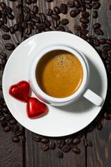 Wall Mural - cup of espresso and chocolate sweets in the form of a heart, vertical top view