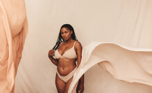Curvy Young Woman Posing In Beige Underwear
