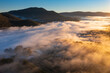 © Austockphoto - Aerial view of early morning sunshine on a mountain valley covered with fog