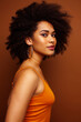 © iordani - pretty young african american woman with curly hair posing cheerful gesturing on brown background, lifestyle people concept