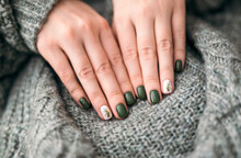 Women's Hands With Stylish Green Autumn Manicure, Against The Background Of A Warm Knitted Plaid. Autumn Season. Close-up. Nail Art