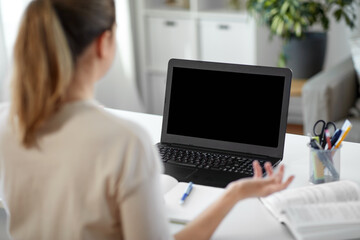 Wall Mural - distant education, remote job and people concept - female student with laptop computer having video call or online class at home office