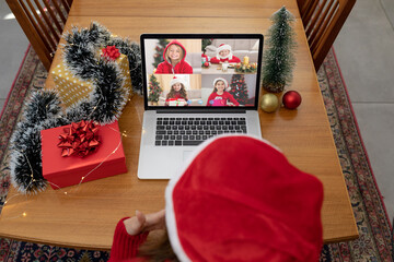 Wall Mural - Caucasian woman in santa hat on christmas laptop video call with friends