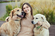 © snedorez - beautiful girl hugs two golden retrievers. Outdoor