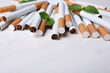Menthol cigarettes and mint on white wooden table. Space for text