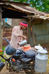 Canvas Print - Rural scene : Indian milkman distribute milk on bike