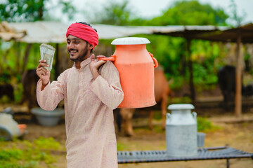 Canvas Print - Rural scene : Indian milkman showing money at his dairy farm