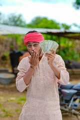 Wall Mural - Happy Indian farmer showing money at home.