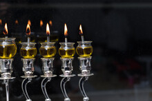 Hanukkah Candles Made Of Olive Oil Are Lit In A Silver Menorah Against The Backdrop Of The Darkness Of The Night