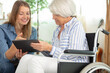 © auremar - woman sitting with her elderly mother using a tablet
