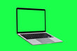 © banphote - Laptop computer with blank green screen isolated on green background.