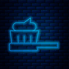 Sticker - Glowing neon line Toothbrush with toothpaste icon isolated on brick wall background. Vector Illustration