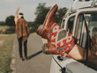 © ADDICTIVE STOCK - Unrecognizable woman in hippie boots lying in retro car near faceless man