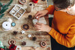 © perfectlab - Young woman wrapping christmas present on table with new year de