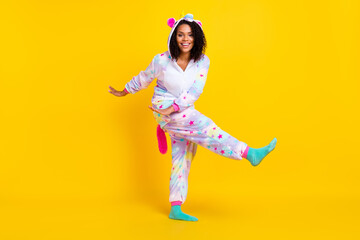 Full length body size view of pretty cheerful girl wearing funny pajama dancing isolated over bright yellow color background