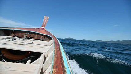 Wall Mural - Wooden long-tail boat sailing on blue sea to the island