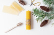 DIY natural beeswax candle for Christmas. Candle, fir branch, pine cones and scissors